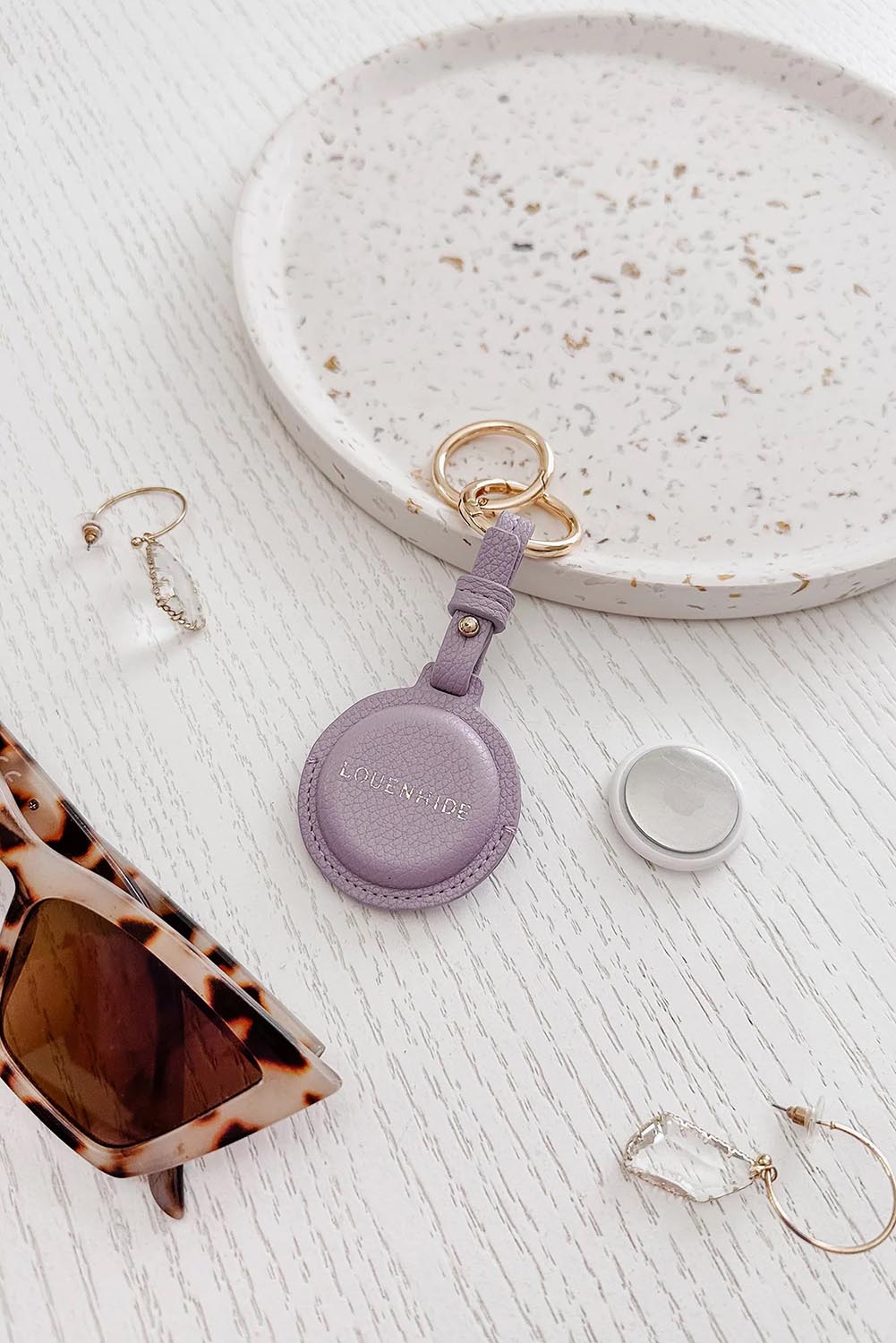 A model wearing the Opal Airtag Holder in colour Lilac (Purple), from the front, showing the whole outfit