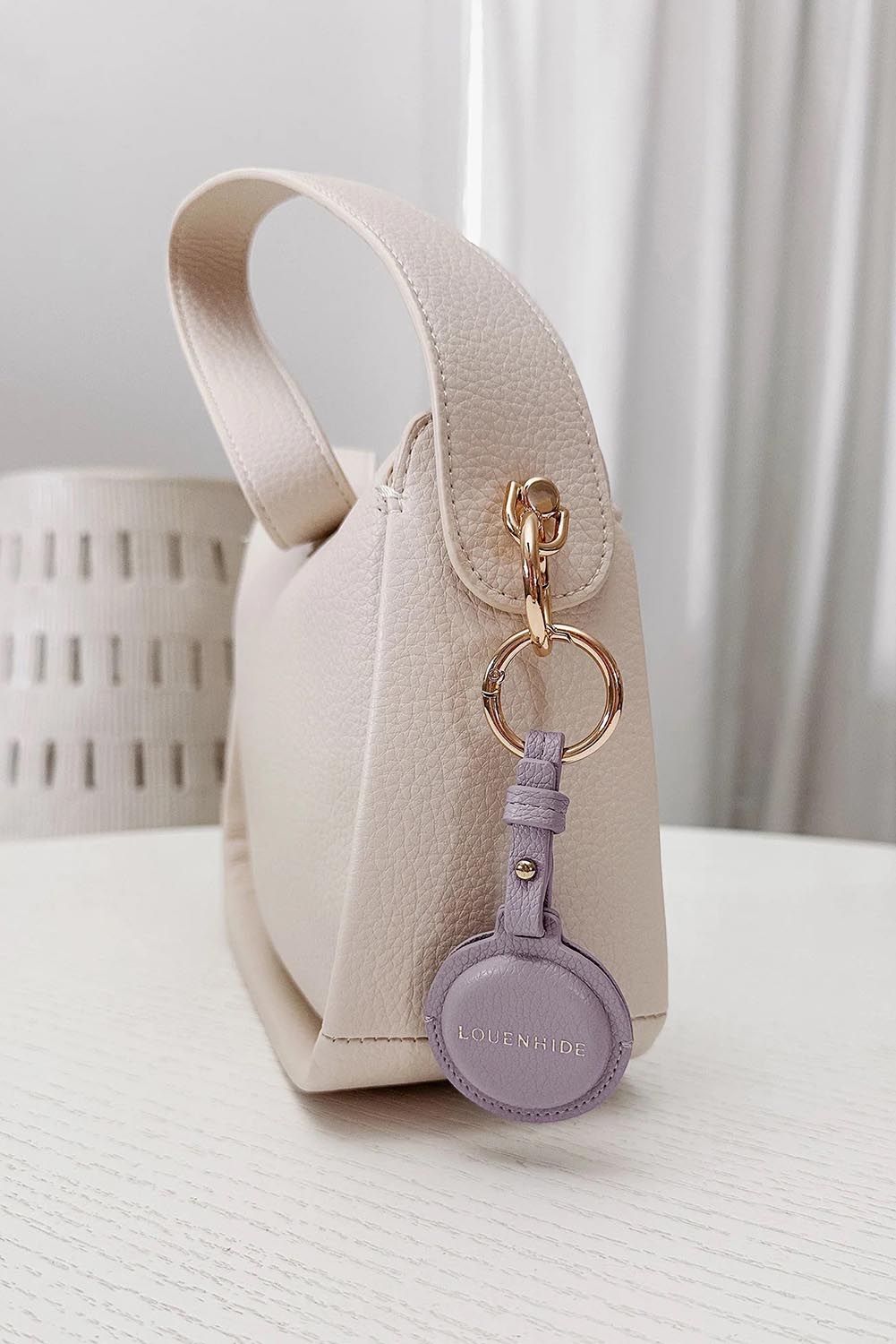 A model wearing the Opal Airtag Holder in colour Lilac (Purple), from the front, showing the whole outfit