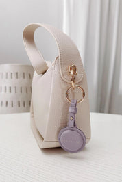 A model wearing the Opal Airtag Holder in colour Lilac (Purple), from the front, showing the whole outfit