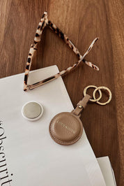 A model wearing the Opal Airtag Holder in colour Mocha, from the front, showing the whole outfit