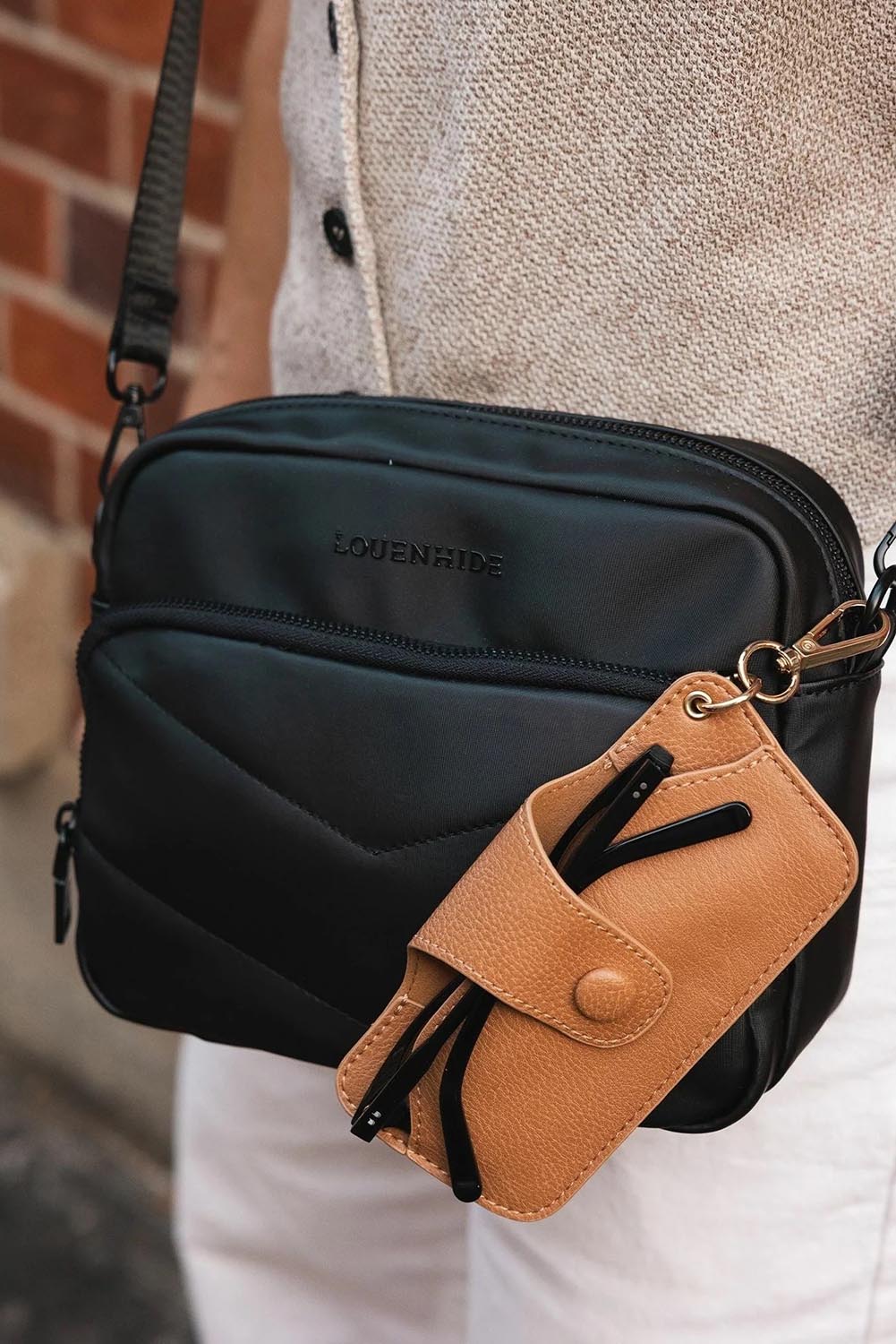 A model wearing the Skittles Glasses Case in colour Camel, from the front, showing the whole outfit