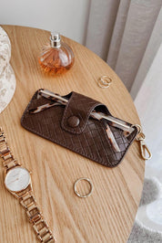 A model wearing the Woven Skittle Glasses Case in colour Chocolate, from the front, showing the whole outfit