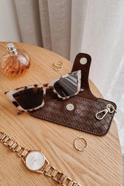 A model wearing the Woven Skittle Glasses Case in colour Chocolate, from the front, showing the whole outfit
