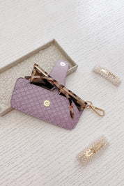 A model wearing the Woven Skittle Glasses Case in colour Lilac (Purple), from the front, showing the whole outfit