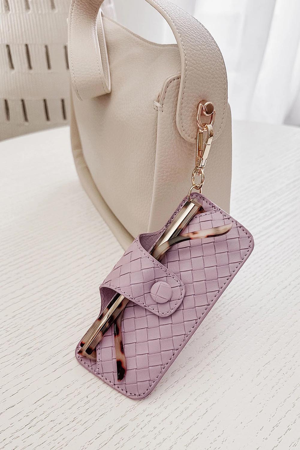 A model wearing the Woven Skittle Glasses Case in colour Lilac (Purple), from the front, showing the whole outfit