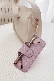 A model wearing the Woven Skittle Glasses Case in colour Lilac (Purple), from the front, showing the whole outfit