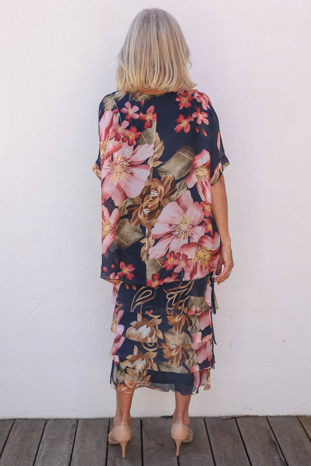 Model Sandy wearing the Silk Blend Multi Layers Dress in colour Navyfloral (Blue), from the back