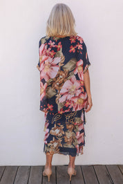 Model Sandy wearing the Silk Blend Multi Layers Dress in colour Navyfloral (Blue), from the back