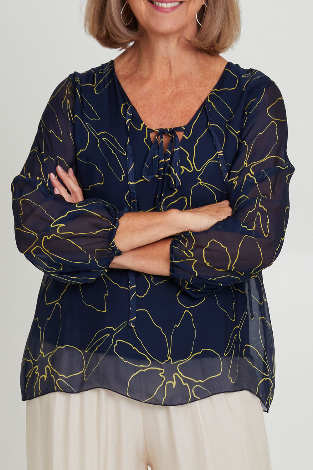 Model Sandy wearing the Silk Blend Vin colourNeck Tied Top - Navyflower (Blue), from the front, cropped image