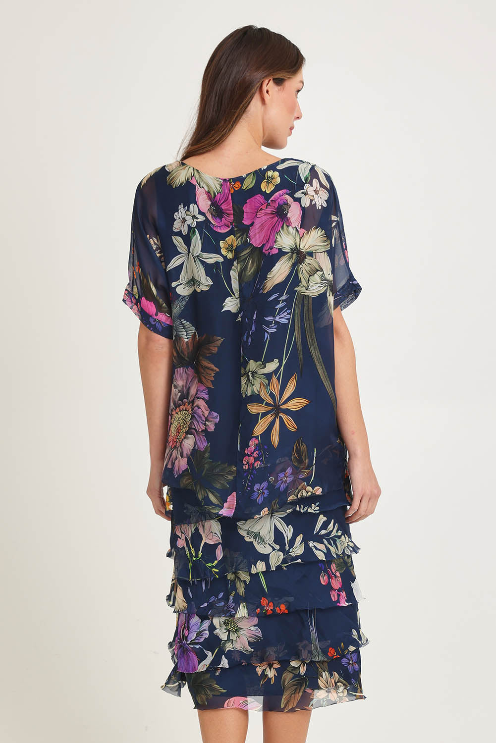 Model Madeline wearing the Silk Blend Multi Layer Print Dress in colour Navyfloral (Blue), from the back