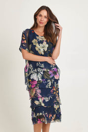 Model Madeline wearing the Silk Blend Multi Layer Print Dress in colour Navyfloral (Blue), from the front, cropped image