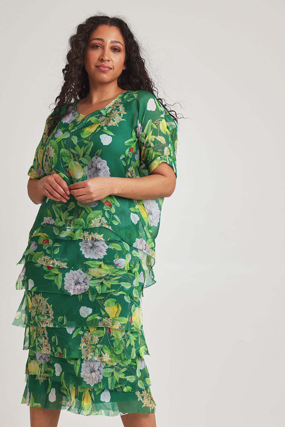 Model Terri-Leigh wearing size L of the Overlay Silk Print Dress in colour Greenflora (Green), from the front, cropped image