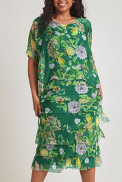 Model Terri-Leigh wearing size L of the Overlay Silk Print Dress in colour Greenflora (Green), from the front, cropped image