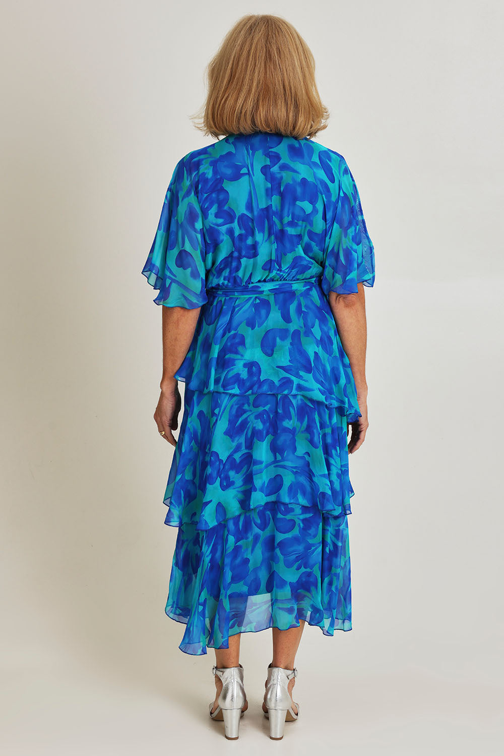 Model Sandy wearing the Short Sleeve Silk Print Dress in colour Cobalt (Blue), from the back