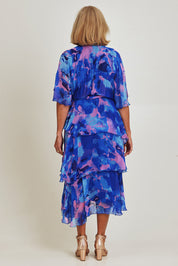 Model Sandy wearing the Short Sleeve Silk Print Dress in colour Cobaltpink (Blue), from the back