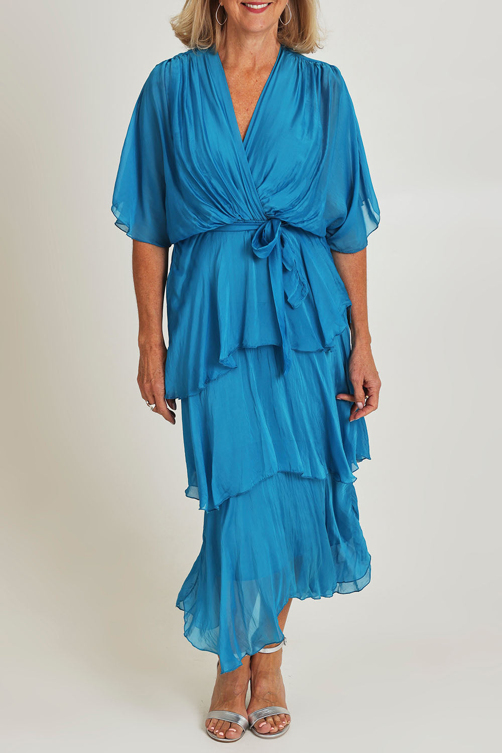 Model Sandy wearing the Short Sleeve Silk Dress in colour Teal (Blue), from the front, cropped image