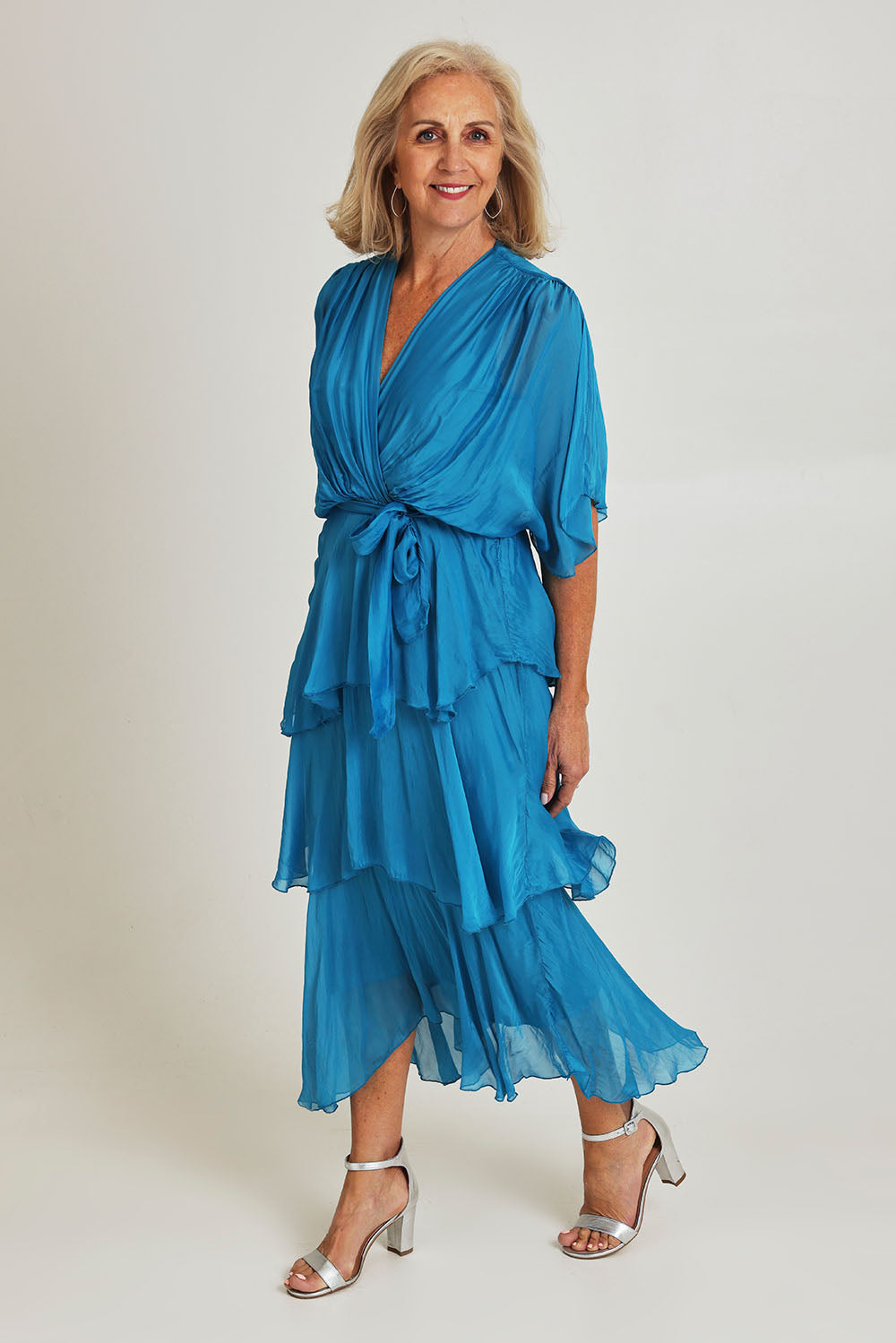 Model Sandy wearing the Short Sleeve Silk Dress in colour Teal (Blue), from the front, showing the whole outfit