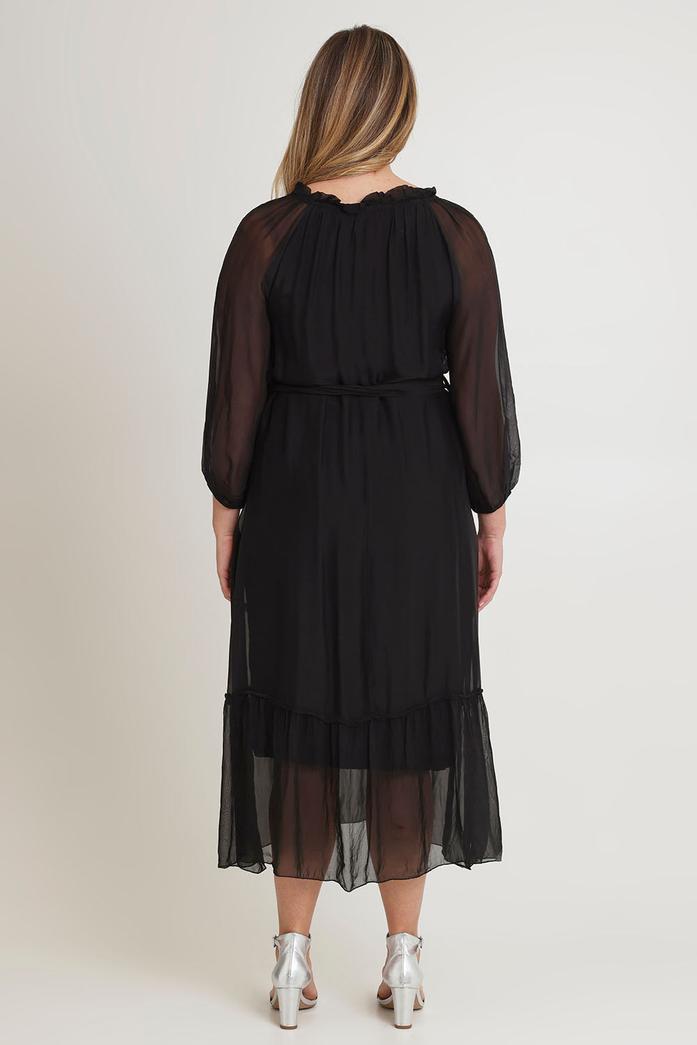 Model Chanel wearing the Long Sleeve Silk Frill Tied Neck Dress in colour Black (Black), from the back