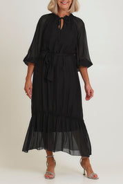 Model Sandy wearing the Long Sleeve Silk Frill Tied Neck Dress in colour Black (Black), from the front, cropped image