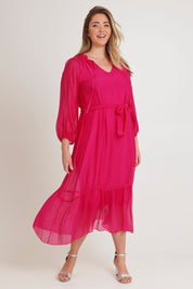 Model Chanel wearing the Long Sleeve Silk Frill Tied Neck Dress in colour Raspberry (Pink), from the front, showing the whole outfit