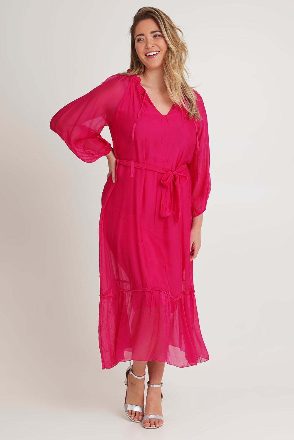 Model Chanel wearing the Long Sleeve Silk Frill Tied Neck Dress in colour Raspberry (Pink), from the front, showing the whole outfit