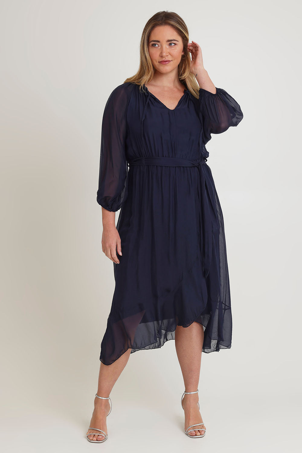 Model Chanel wearing the Long Sleeve Silk Frill Tied Neck Knee Length Dress in colour Navy (Blue), from the front, showing the whole outfit