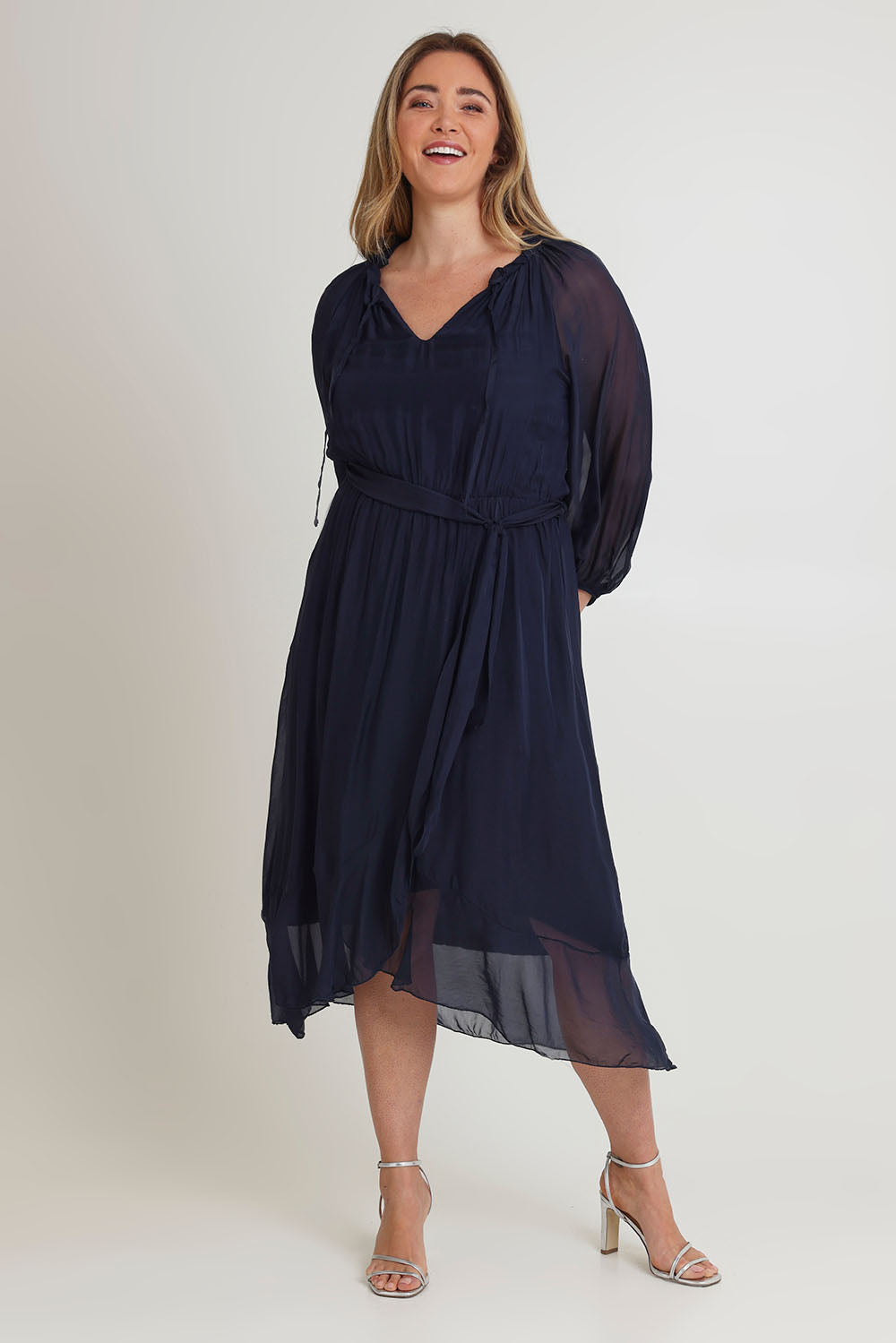Model Chanel wearing the Long Sleeve Silk Frill Tied Neck Knee Length Dress in colour Navy (Blue), from the front, showing the whole outfit
