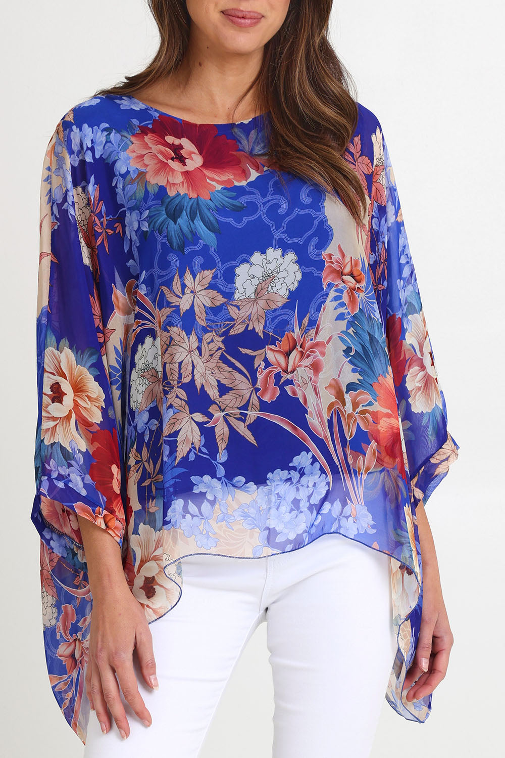 Model Madeline wearing the Silk Kaftan Top in colour Bluefloral (Blue), from the front, cropped image