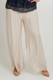 Model Sandy wearing the Silk Pant in colour Beige, from the front, cropped image