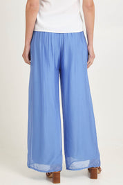 Model Madeline wearing the Silk Pant in colour Blueturco (Blue), from the back