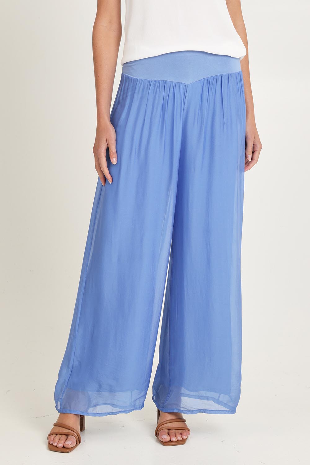 Model Madeline wearing the Silk Pant in colour Blueturco (Blue), from the front, cropped image