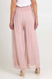 Model Madeline wearing the Silk Pant in colour BlushPink (Pink), from the back