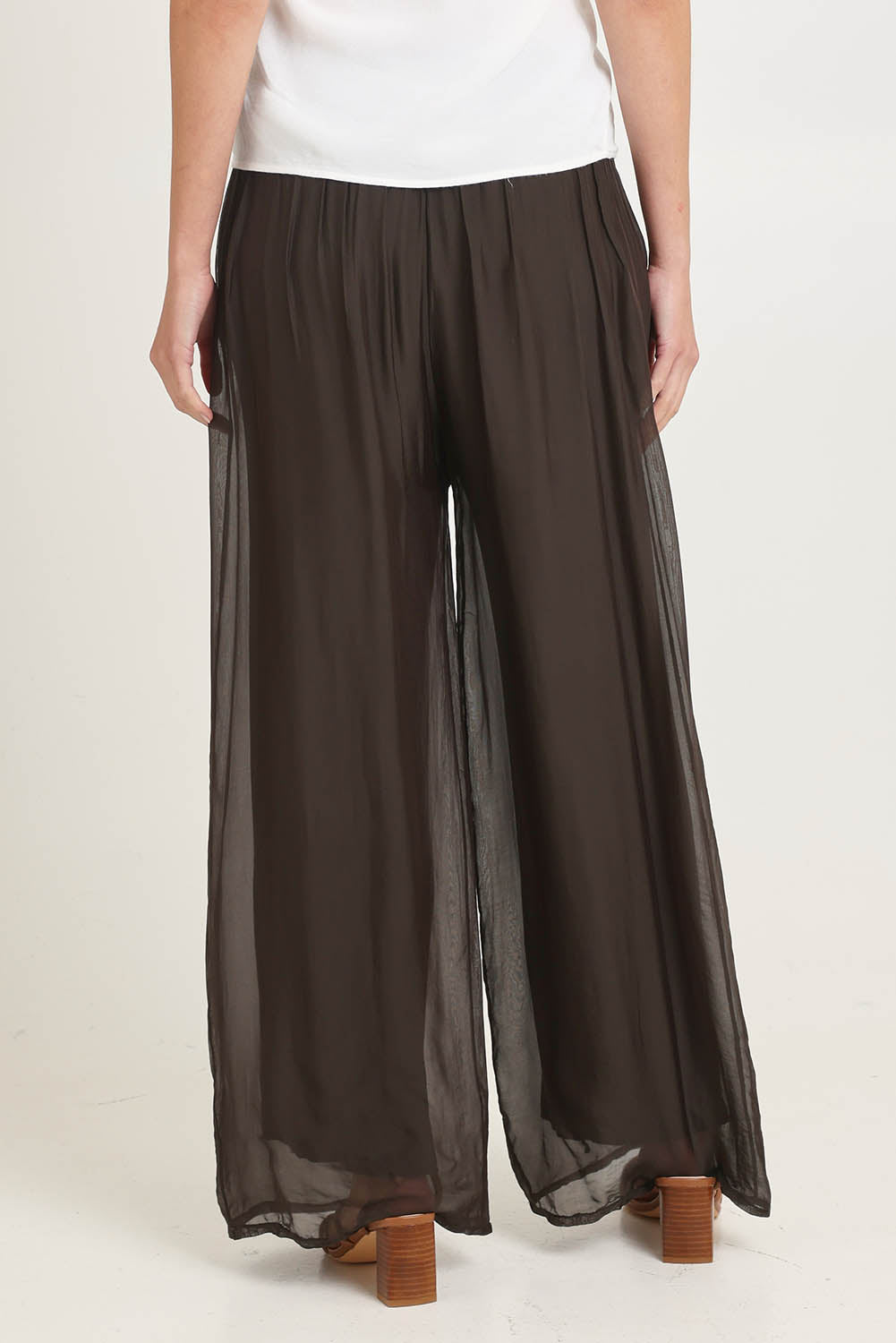 Model Madeline wearing the Silk Pant in colour Moro, from the back