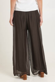 Model Madeline wearing the Silk Pant in colour Moro, from the back