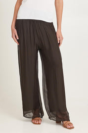 Model Madeline wearing the Silk Pant in colour Moro, from the front, cropped image