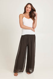 Model Madeline wearing the Silk Pant in colour Moro, from the front, showing the whole outfit