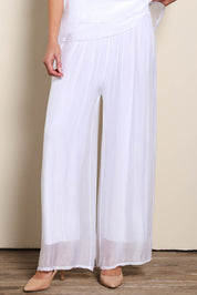 Model Maddiec wearing size 10 of the Silk Pant - White in colour White, in a cropped view