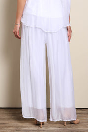Model Maddiec wearing size 10 of the Silk Pant - White in colour White, in a cropped view