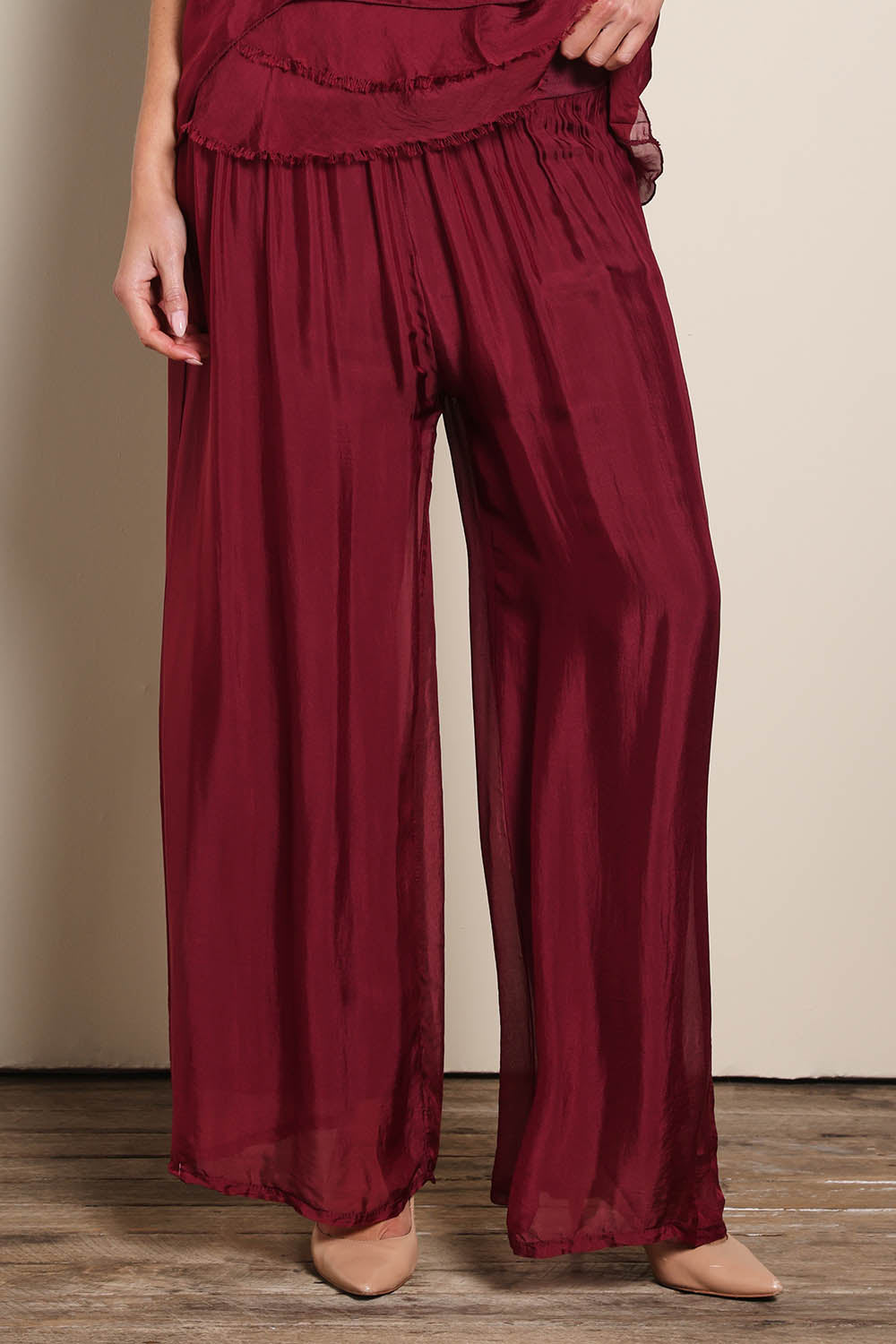 Model Maddiec wearing size 10 of the Silk Pant - Wine in colour Wine, in a cropped view