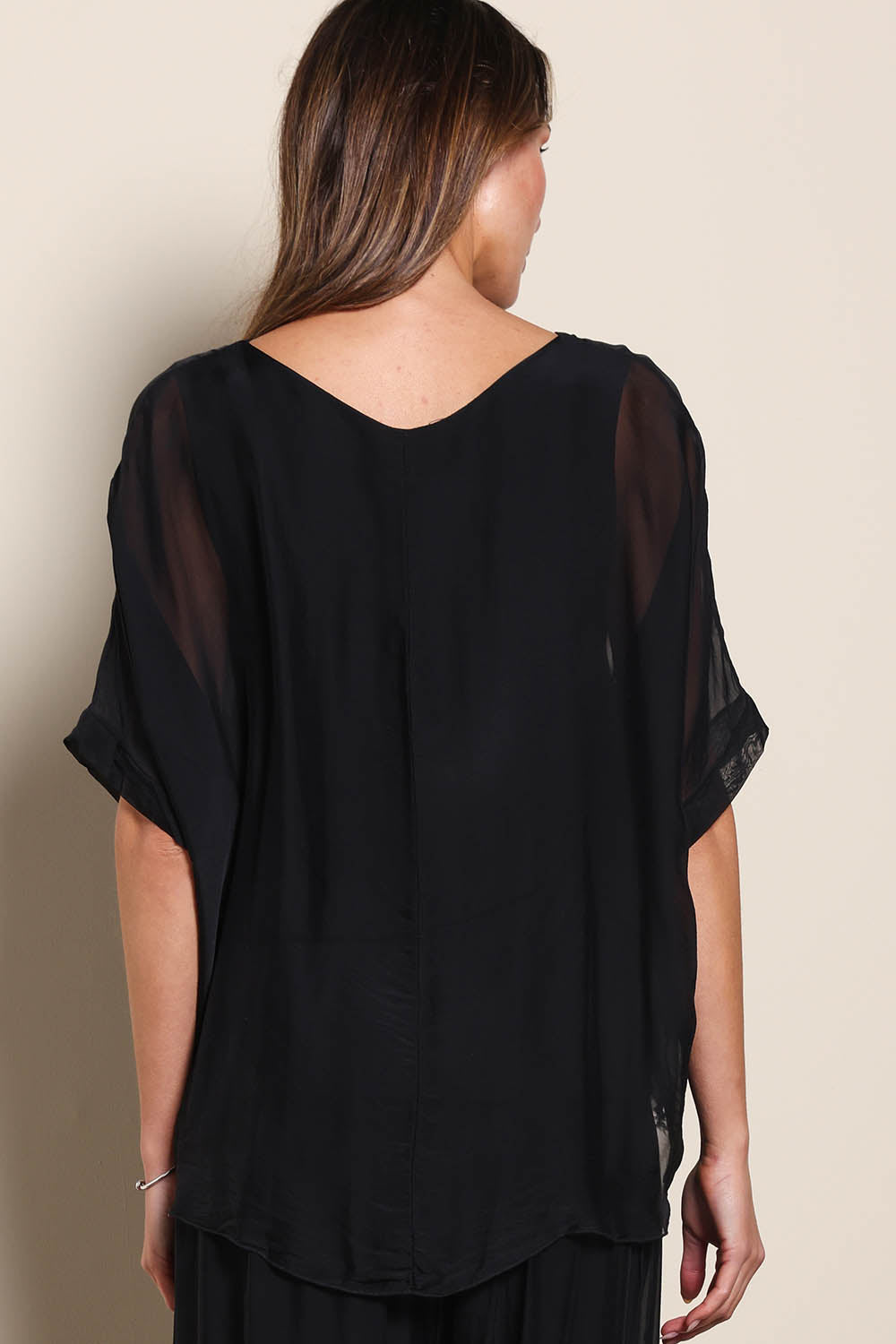 Model Maddiec wearing size 10 of the Silk Blend Three Layer Raw Edge Top - Black in colour Black, from the back