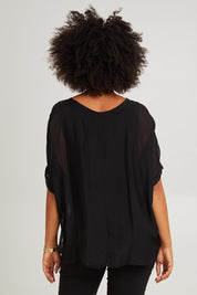 Model Olivia wearing the Silk Blend Three Layer Raw Edge Top in colour Black (Black), from the back