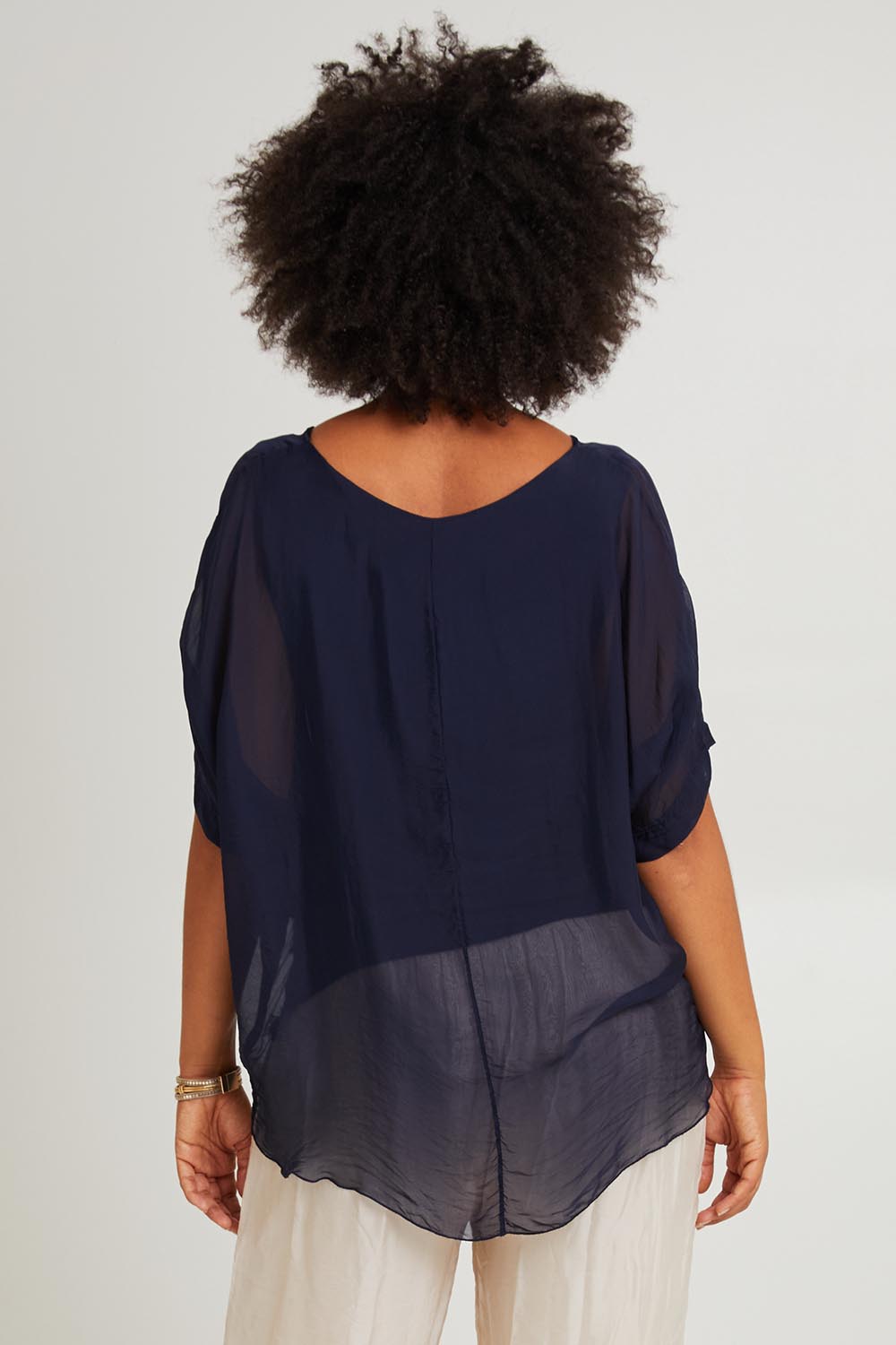 Model Olivia wearing the Silk Blend Three Layer Raw Edge Top in colour Navy (Blue), from the back