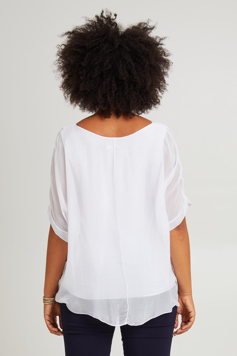 Model Olivia wearing the Silk Blend Three Layer Raw Edge Top in colour White (White), from the back