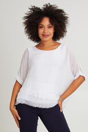 Model Olivia wearing the Silk Blend Three Layer Raw Edge Top in colour White (White), from the front, cropped image