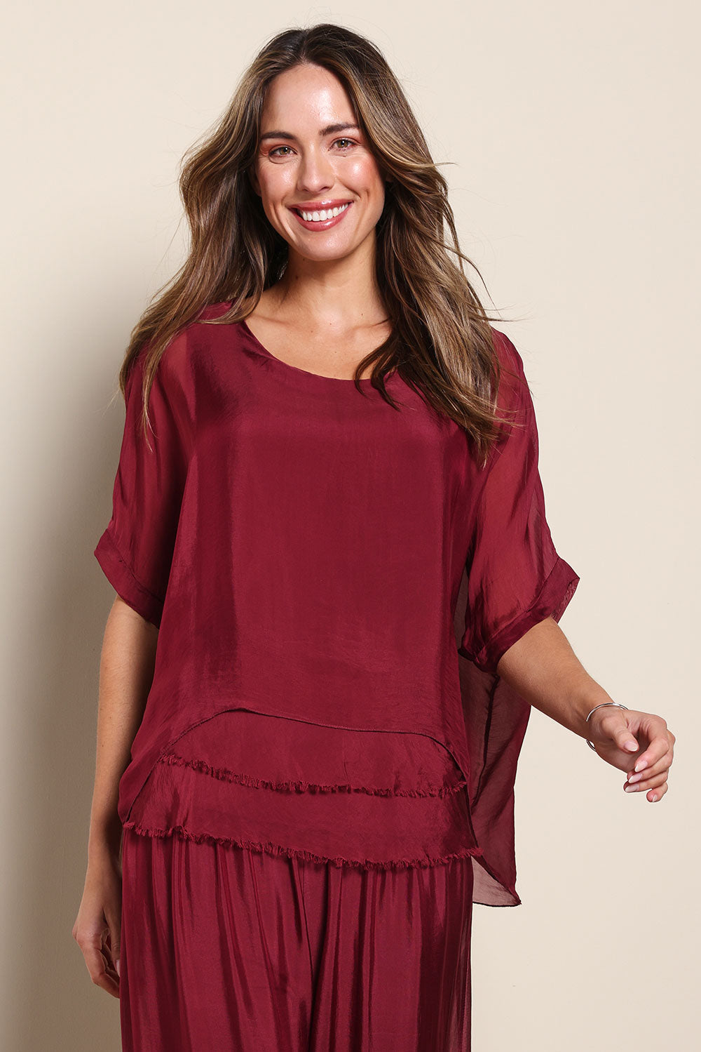 Model Madelinec wearing size 10 of the Silk Blend Three Layer Raw Edge Top - Wine in colour Wine, in a cropped view