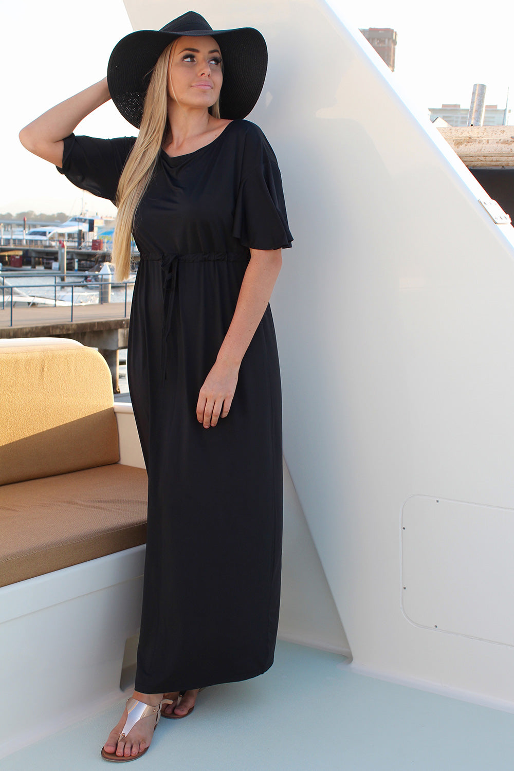 A model wearing the Indie Maxi Tanning Dress in colour Black (Black), from the front, showing the whole outfit
