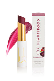 A model wearing the Cherry Plum Lip Nourish in colour Cherry (Red), from the front, showing the whole outfit