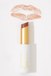 A model wearing the Mandarin Spice Lip Nourish in colour Mand, from the front, showing the whole outfit