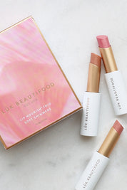 A model wearing the Lip Nourish Trio in colour Shimmers (Pink), from the front, showing the whole outfit