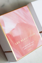 A model wearing the Lip Nourish Trio in colour Shimmers (Pink), from the front, showing the whole outfit